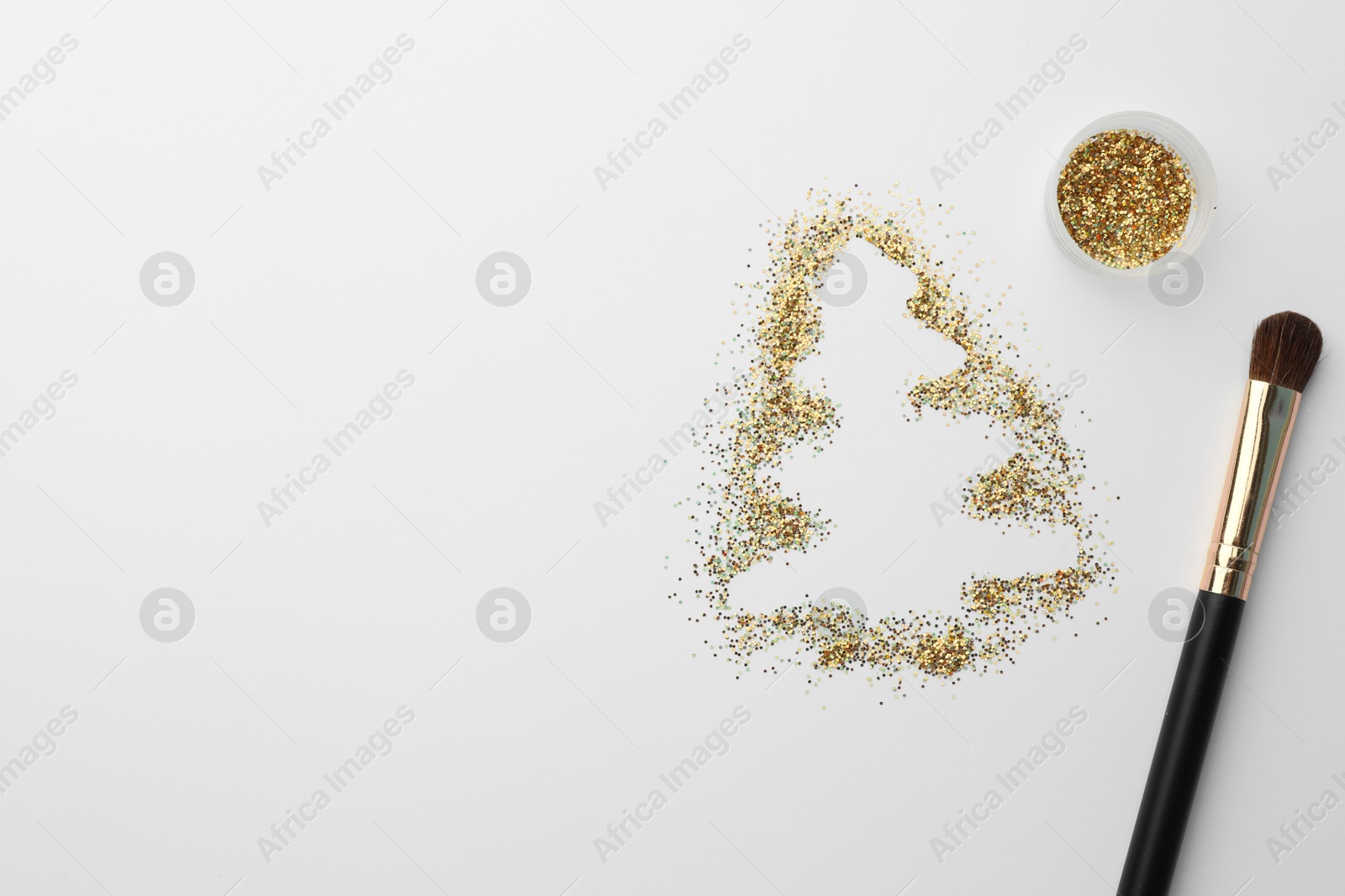 Photo of Christmas tree made of glitter and makeup brush on white background, flat lay. Space for text