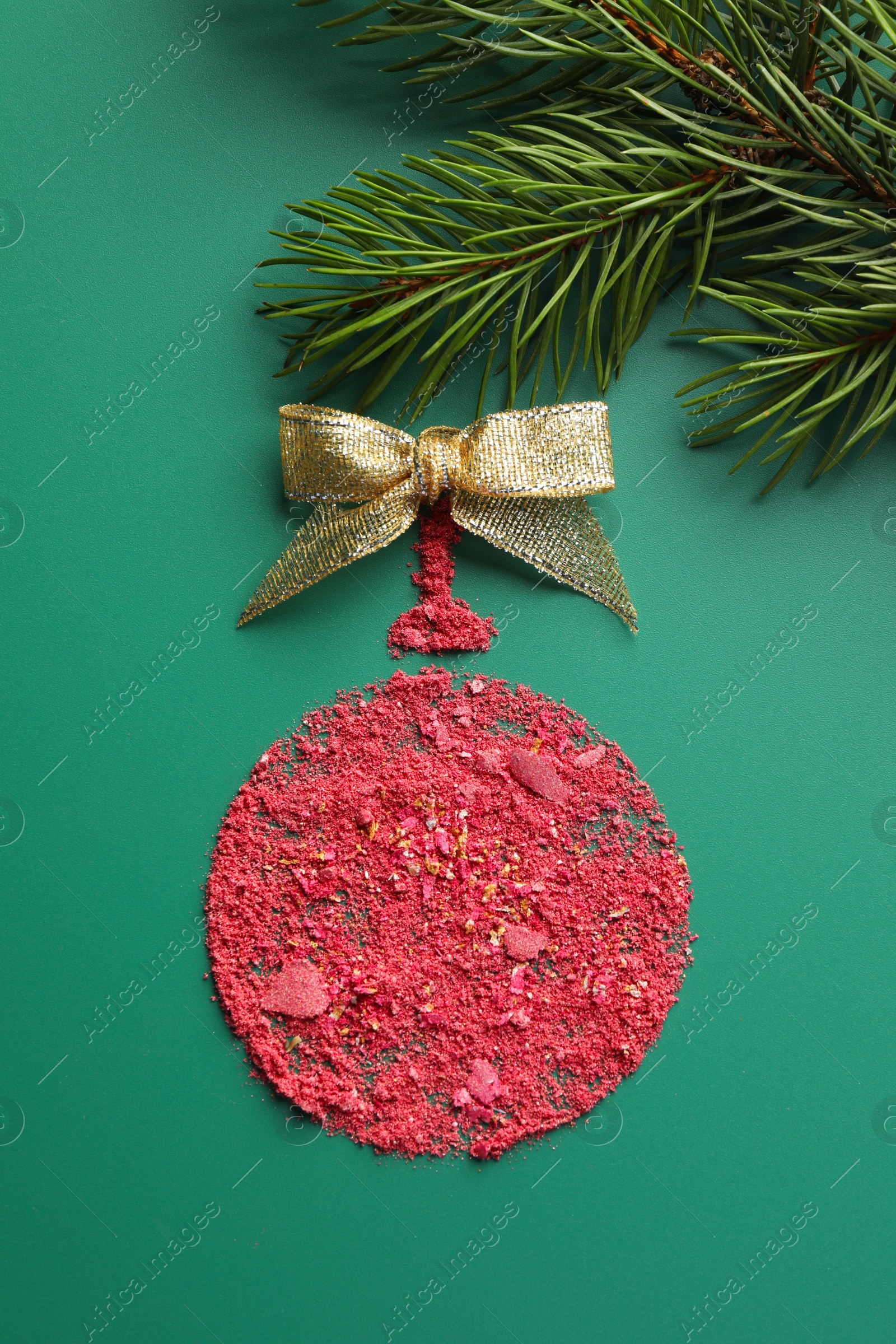 Photo of Christmas ball made of blush with bow and fir branch on green background, top view