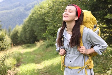 Young hiker with backpack in forest, space for text