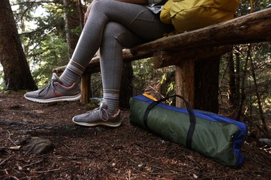 Young hiker wearing sneakers in forest, closeup