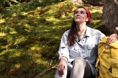 Photo of Young hiker with backpack resting in forest