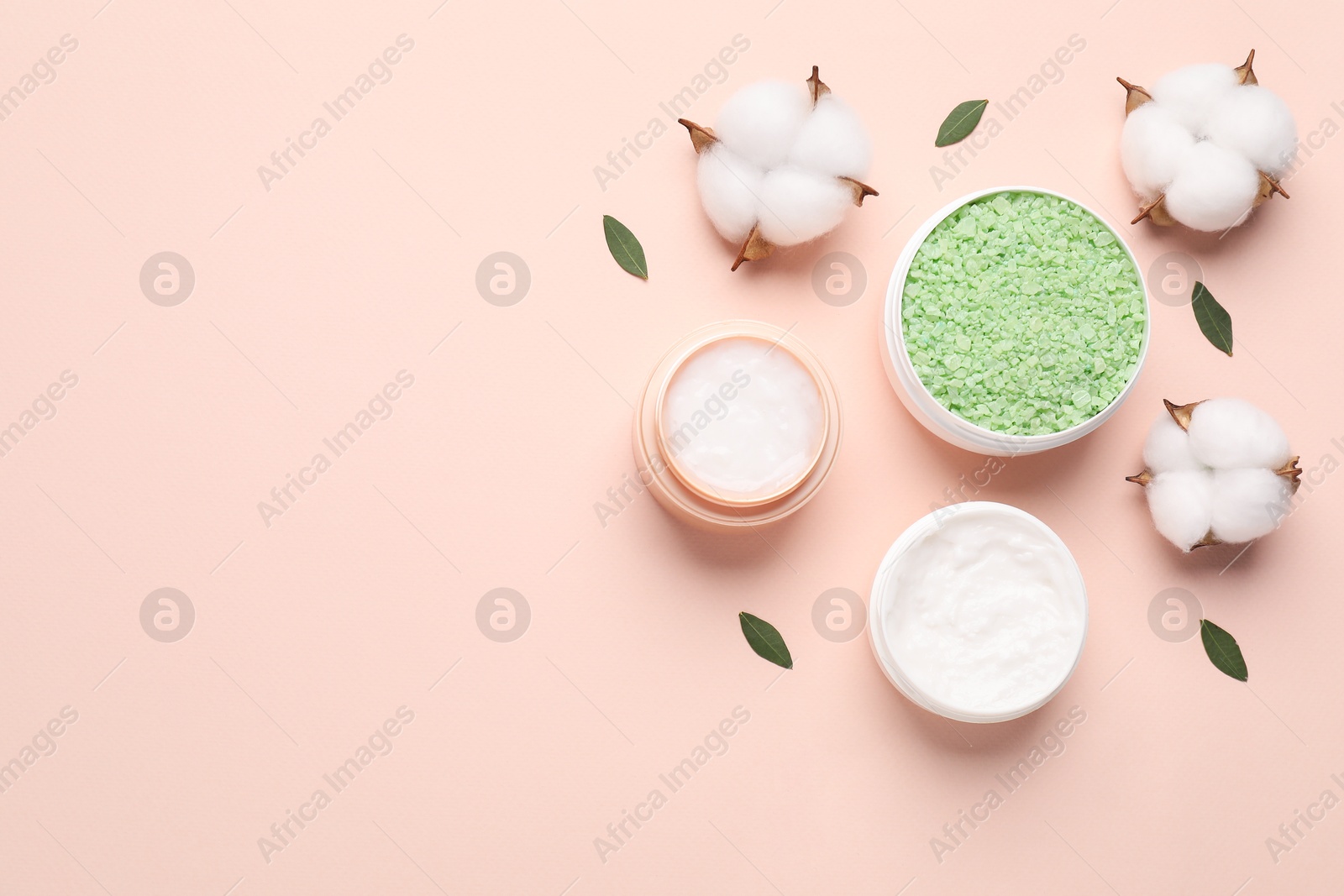 Photo of Different cosmetic products, leaves and cotton flowers on beige background, flat lay. Space for text