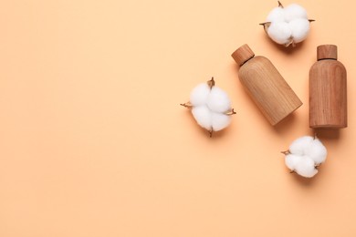 Photo of Different cosmetic products and cotton flowers on pale orange background, flat lay. Space for text