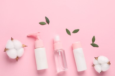 Photo of Different cosmetic products, leaves and cotton flowers on pink background, flat lay. Space for text