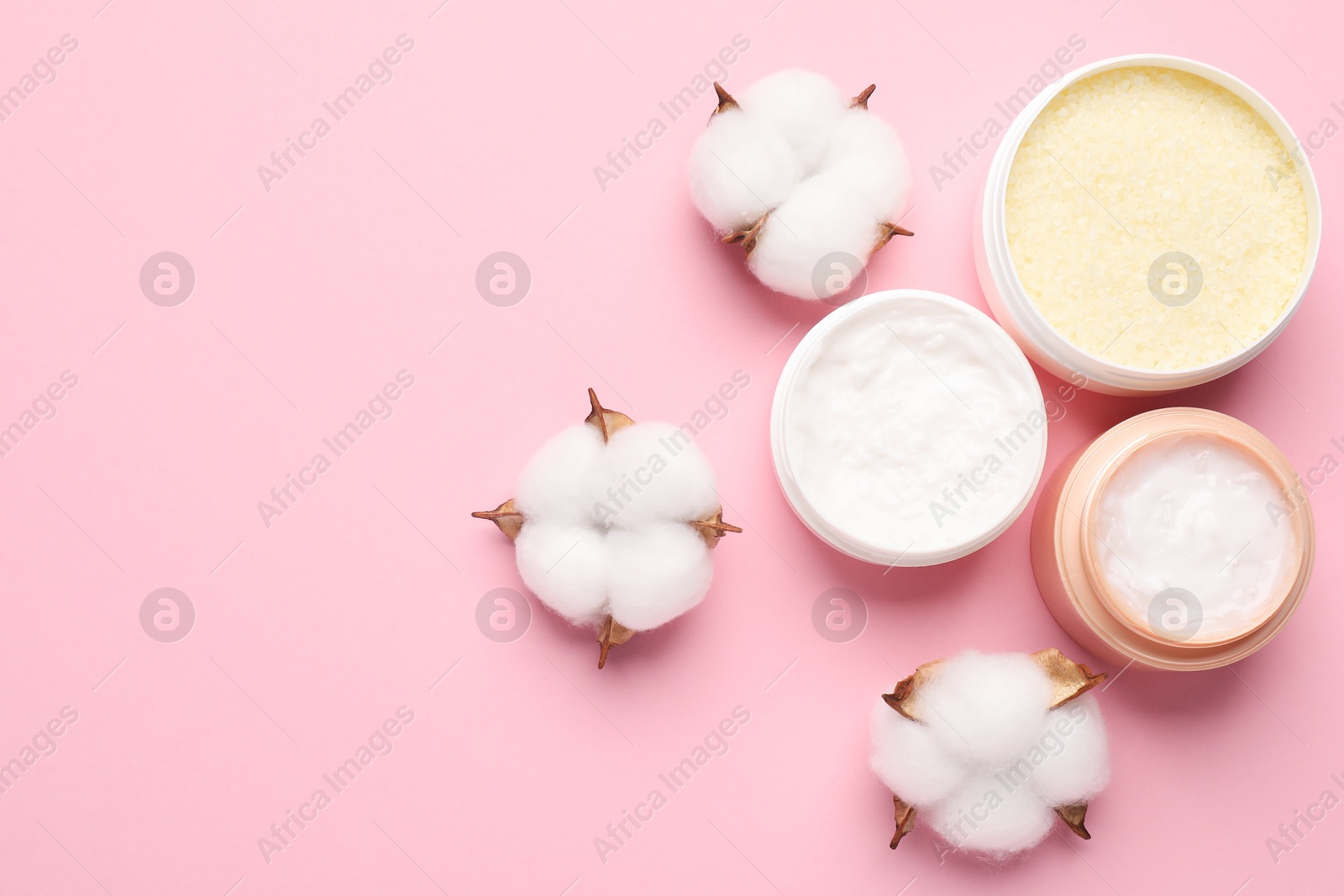 Photo of Different cosmetic products and cotton flowers on pink background, flat lay. Space for text