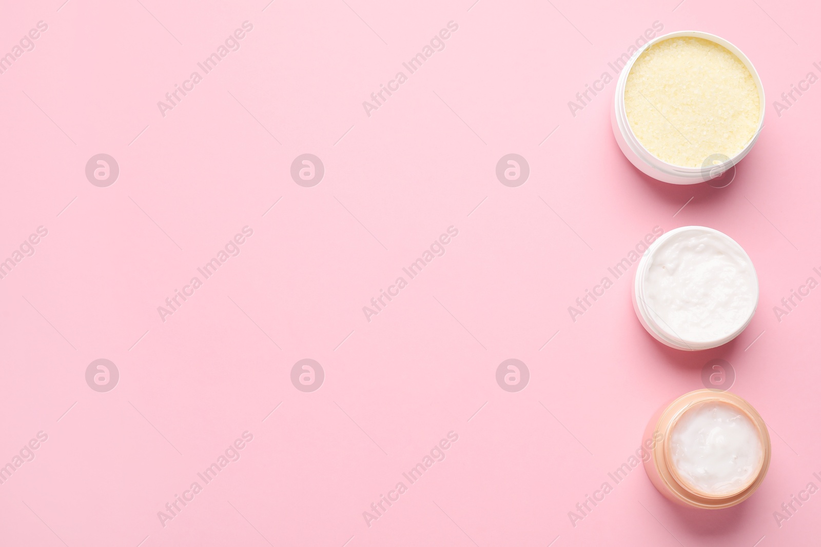 Photo of Different cosmetic products on pink background, flat lay. Space for text