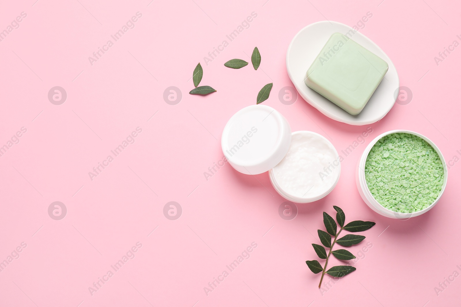 Photo of Different cosmetic products and leaves on pink background, flat lay. Space for text