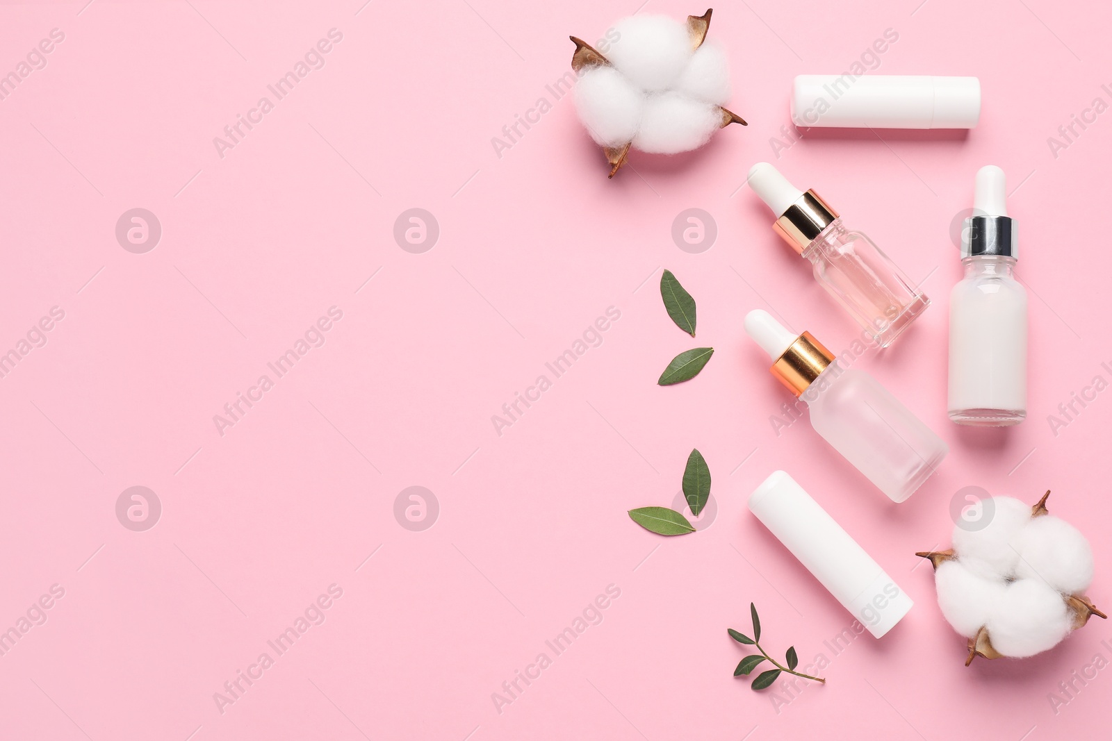 Photo of Different cosmetic products, leaves and cotton flowers on pink background, flat lay. Space for text