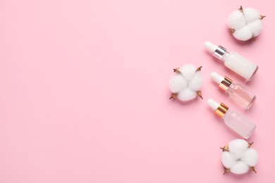 Photo of Different cosmetic products and cotton flowers on pink background, flat lay. Space for text