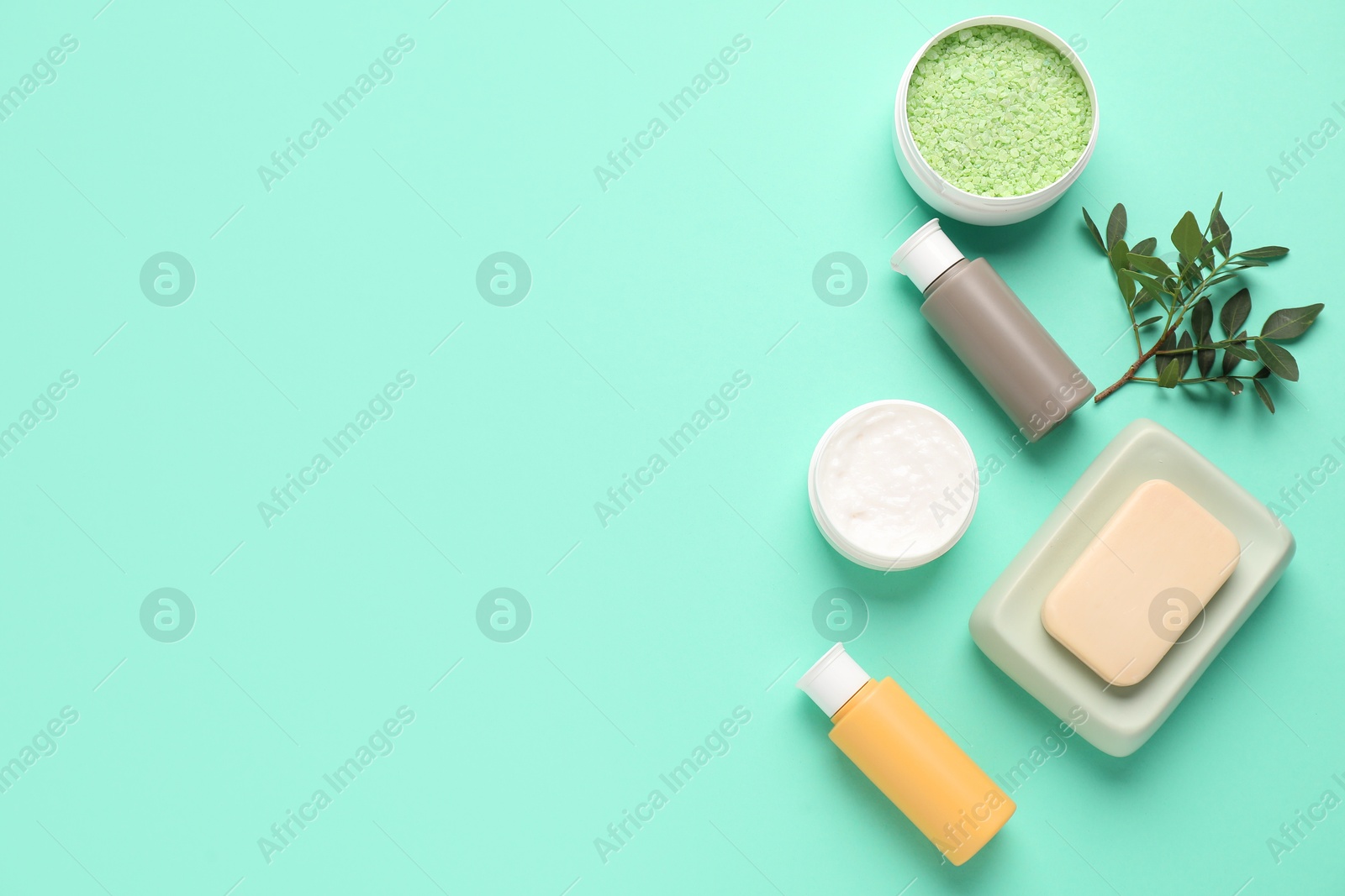 Photo of Different cosmetic products and leaves on turquoise background, flat lay. Space for text