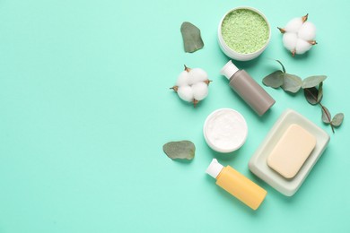 Photo of Different cosmetic products, leaves and cotton flowers on turquoise background, flat lay. Space for text