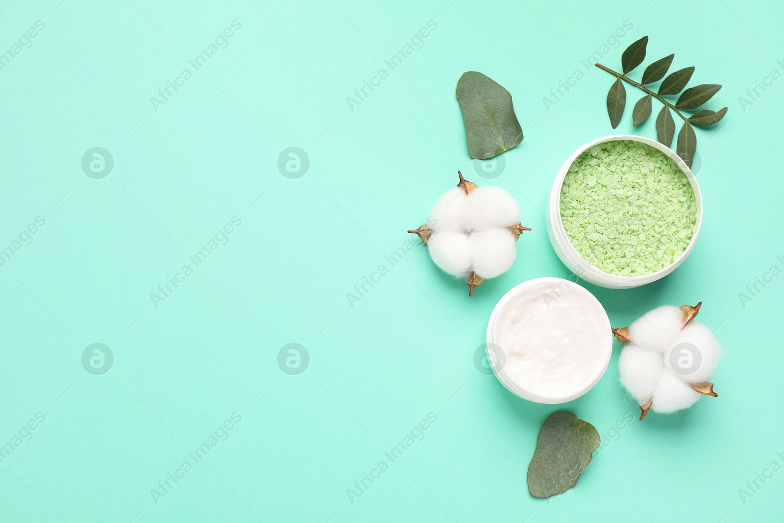 Photo of Different cosmetic products, leaves and cotton flowers on turquoise background, flat lay. Space for text