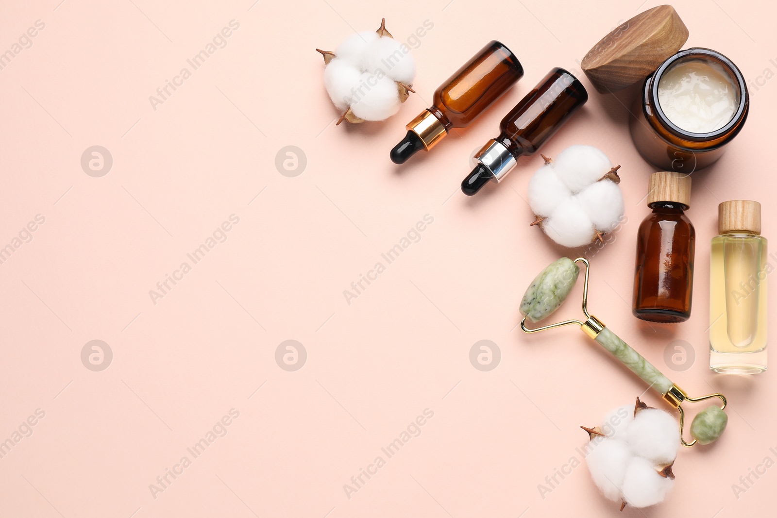 Photo of Different cosmetic products and cotton flowers on beige background, flat lay. Space for text