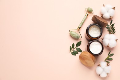 Photo of Different cosmetic products, green leaves and cotton flowers on beige background, flat lay. Space for text