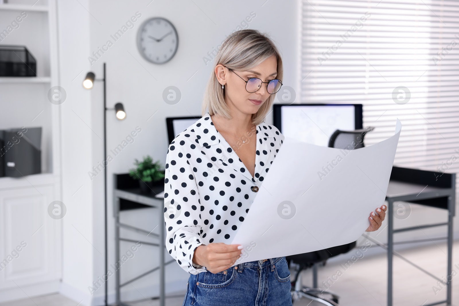 Photo of Architect holding paper sheet with engineering drawing in office