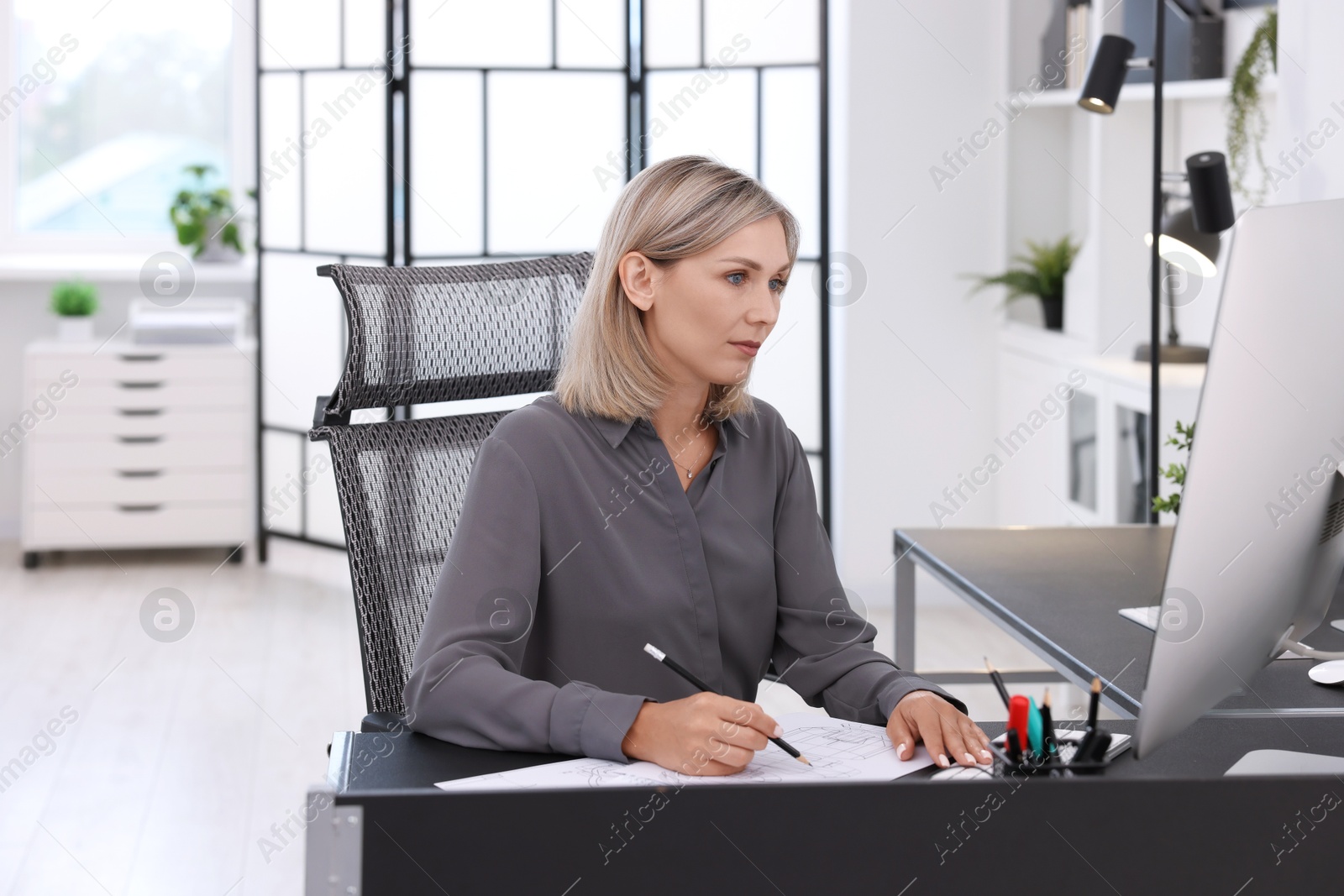 Photo of Architect making engineering drawing at table in office