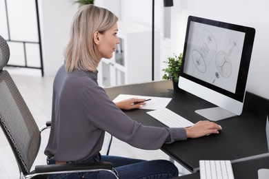 Photo of Architect making digital engineering drawing on computer at table in office