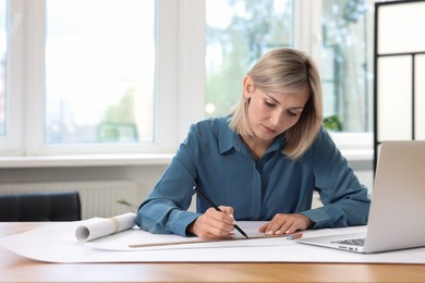 Photo of Architect making engineering drawing at table in office