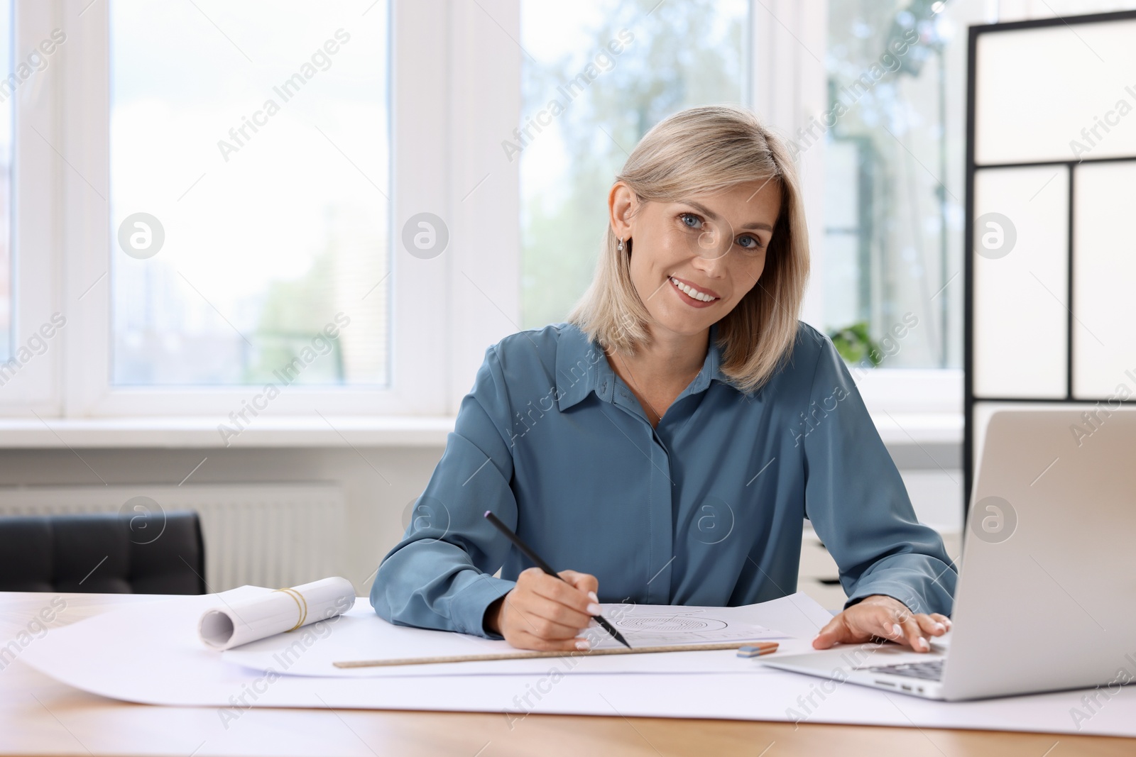 Photo of Architect making engineering drawing at table in office