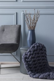 Photo of Stylish stool, chair and vase near light grey wall indoors