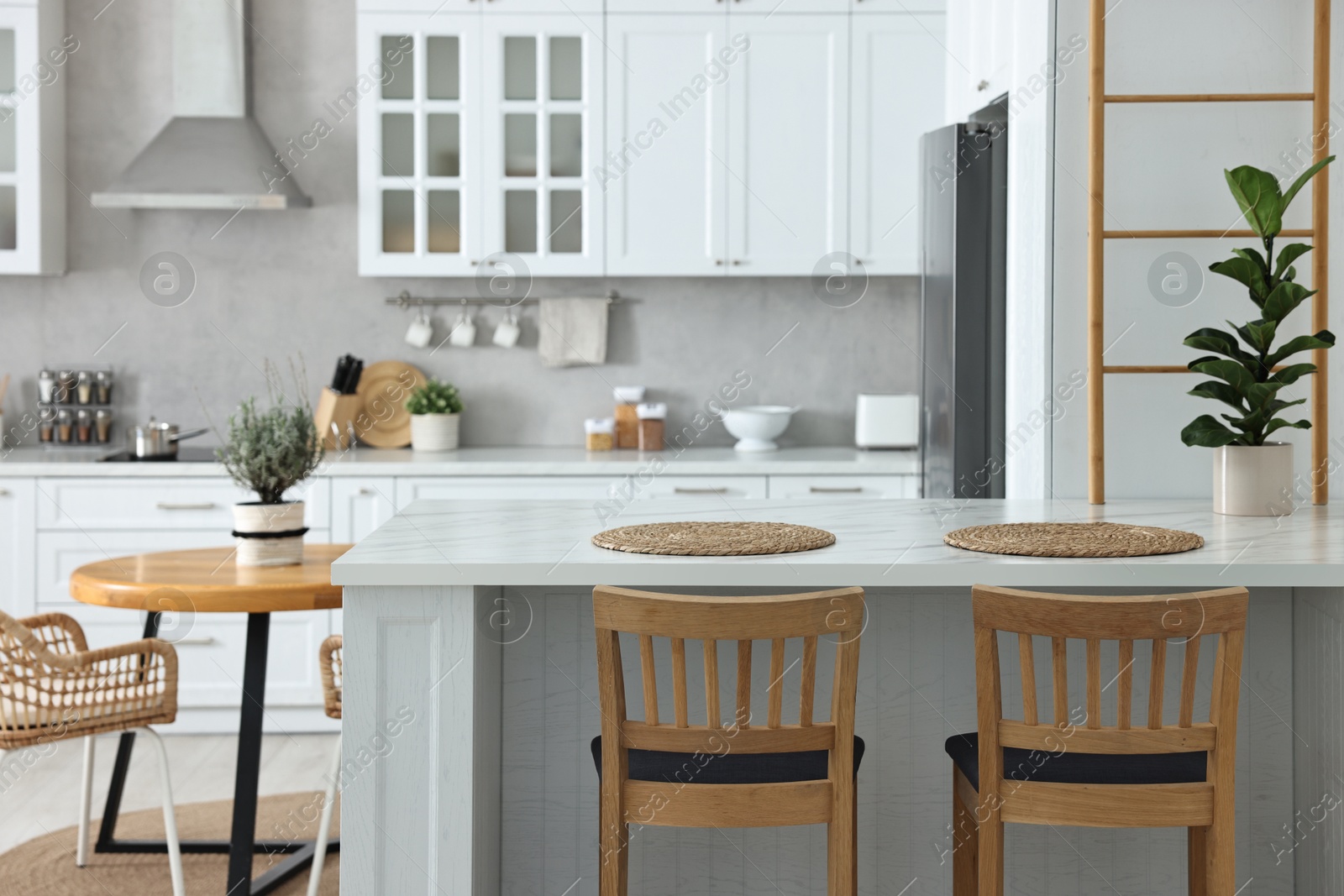 Photo of Stylish kitchen with bar stools. Interior design