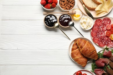 Photo of Different tasty food served for brunch on white wooden table, flat lay. Space for text