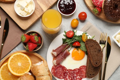 Photo of Different tasty food served for brunch on grey marble table, flat lay