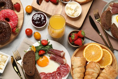 Photo of Different tasty food served for brunch on grey marble table, flat lay