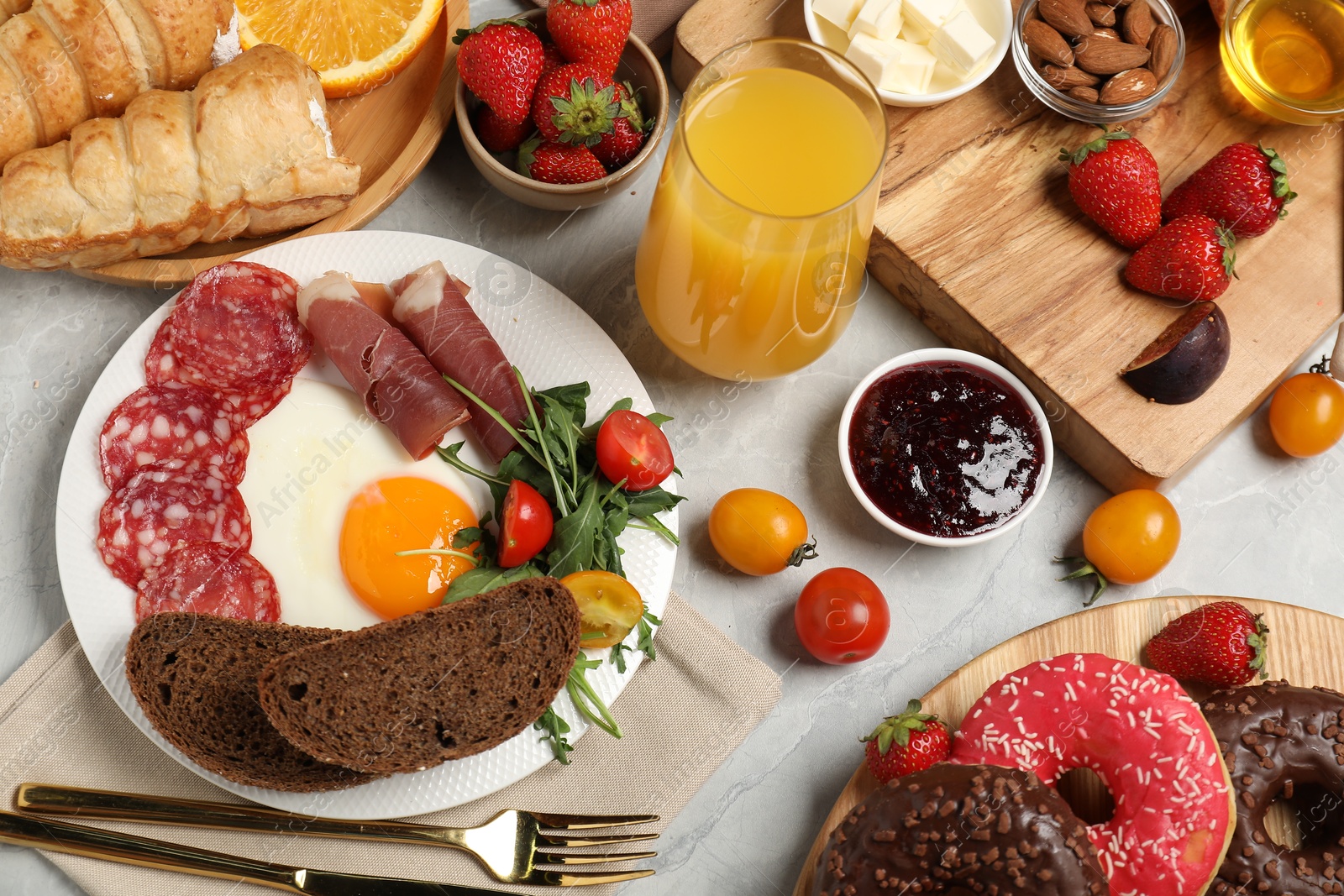 Photo of Different tasty food served for brunch on grey marble table, flat lay