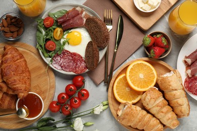 Photo of Different tasty food served for brunch on grey marble table, flat lay