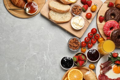 Photo of Different tasty food served for brunch on grey marble table, flat lay. Space for text