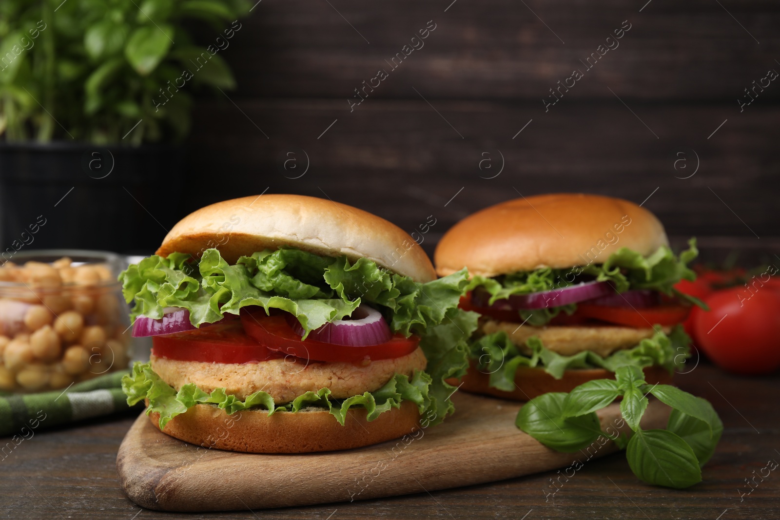 Photo of Delicious vegetarian burgers with chickpea cutlets on wooden table