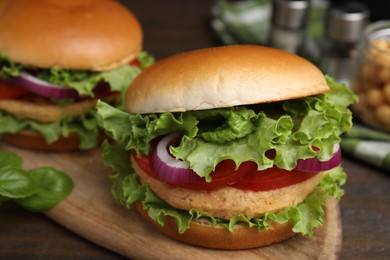 Photo of Delicious vegetarian burgers with chickpea cutlets on wooden table, closeup