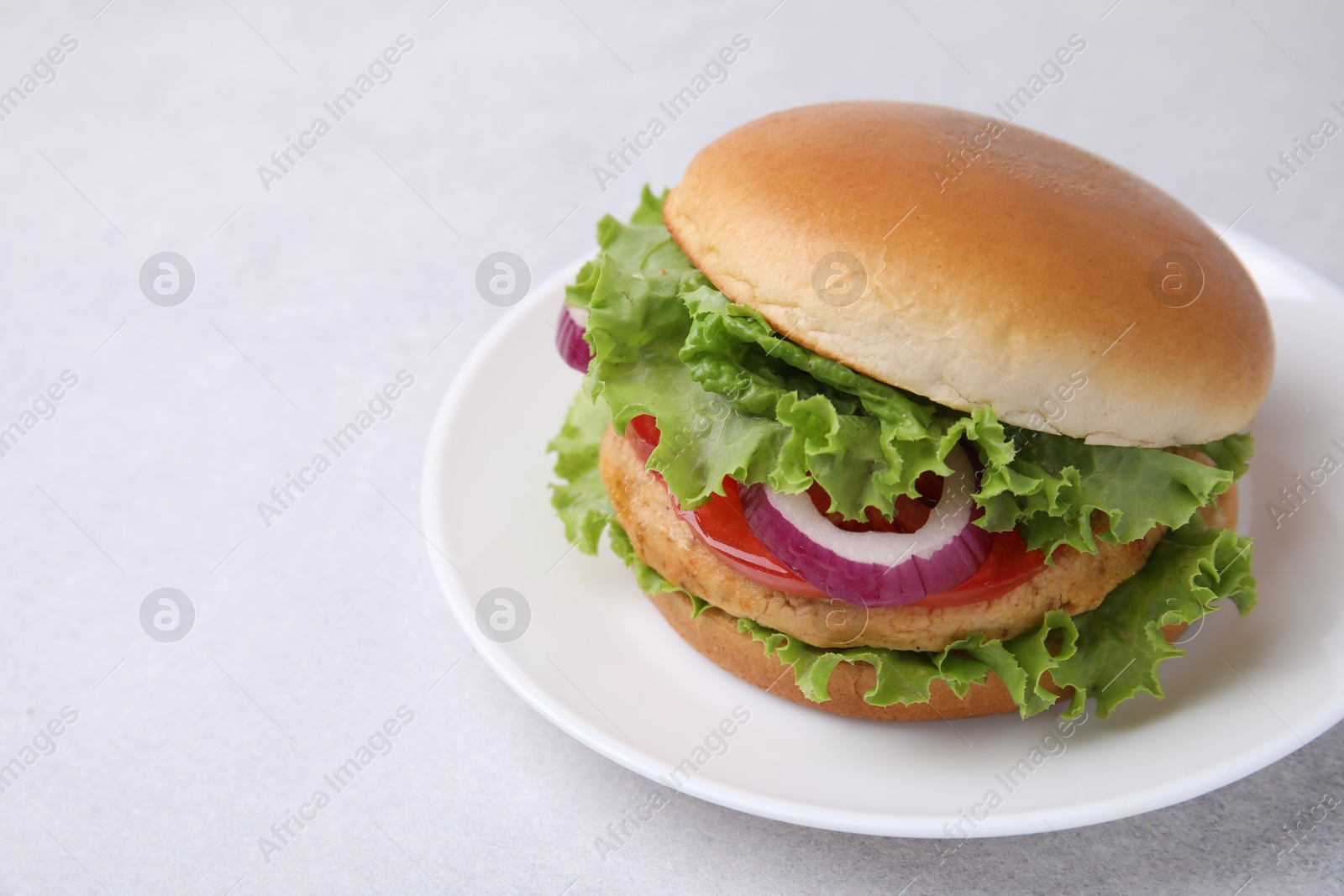 Photo of Delicious vegetarian burger with chickpea cutlet on light table, closeup. Space for text