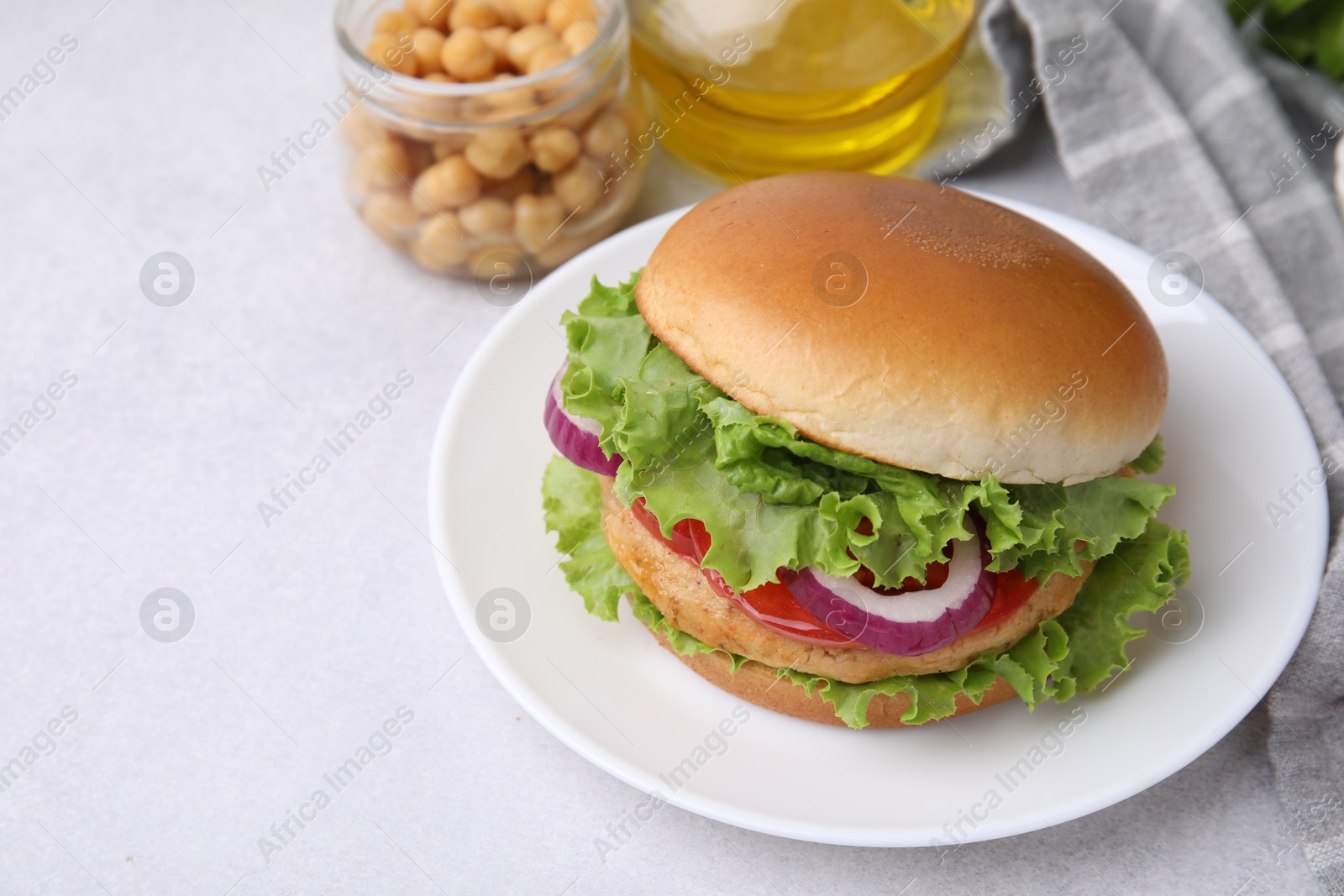 Photo of Delicious vegetarian burger with chickpea cutlet on light table. Space for text