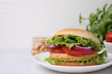 Photo of Delicious vegetarian burger with chickpea cutlet on light table, closeup. Space for text