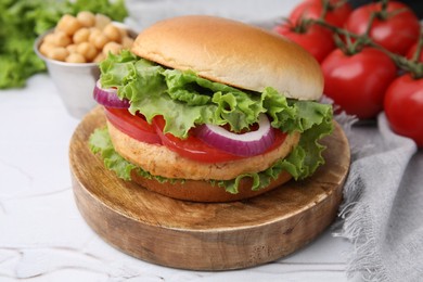 Photo of Delicious vegetarian burger with chickpea cutlet on white table, closeup