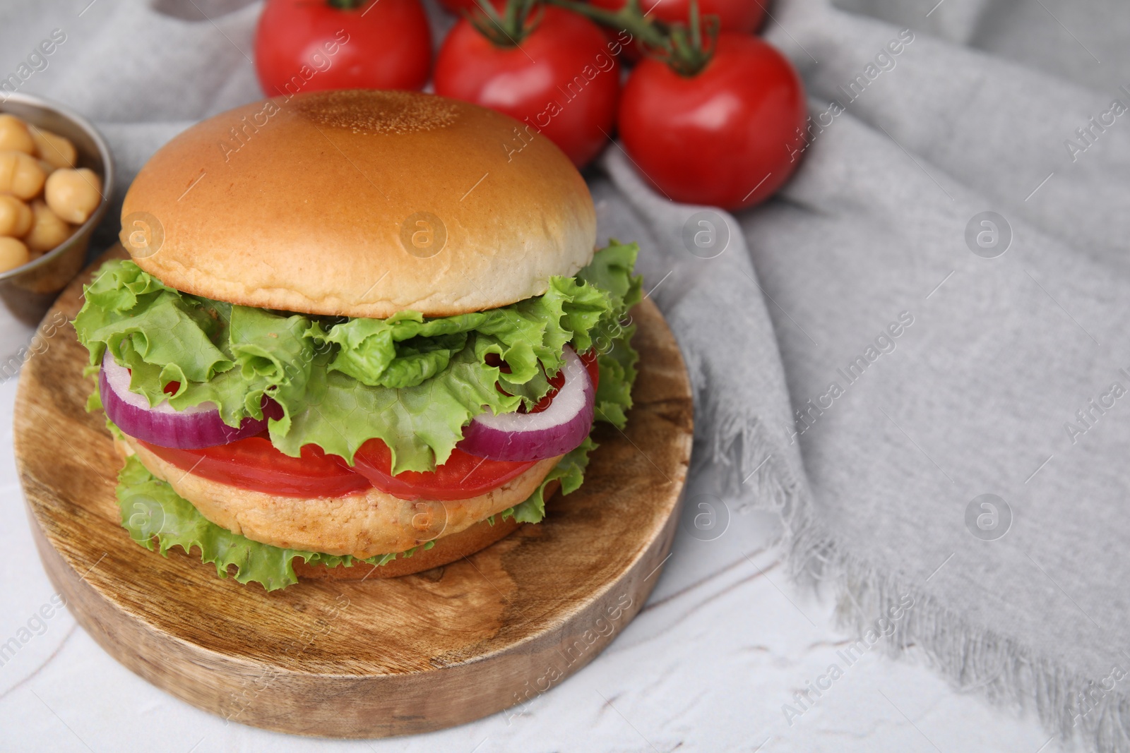 Photo of Delicious vegetarian burger with chickpea cutlet on white table. Space for text