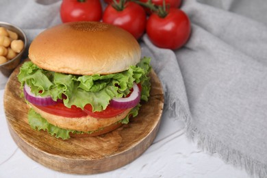 Photo of Delicious vegetarian burger with chickpea cutlet on white table. Space for text