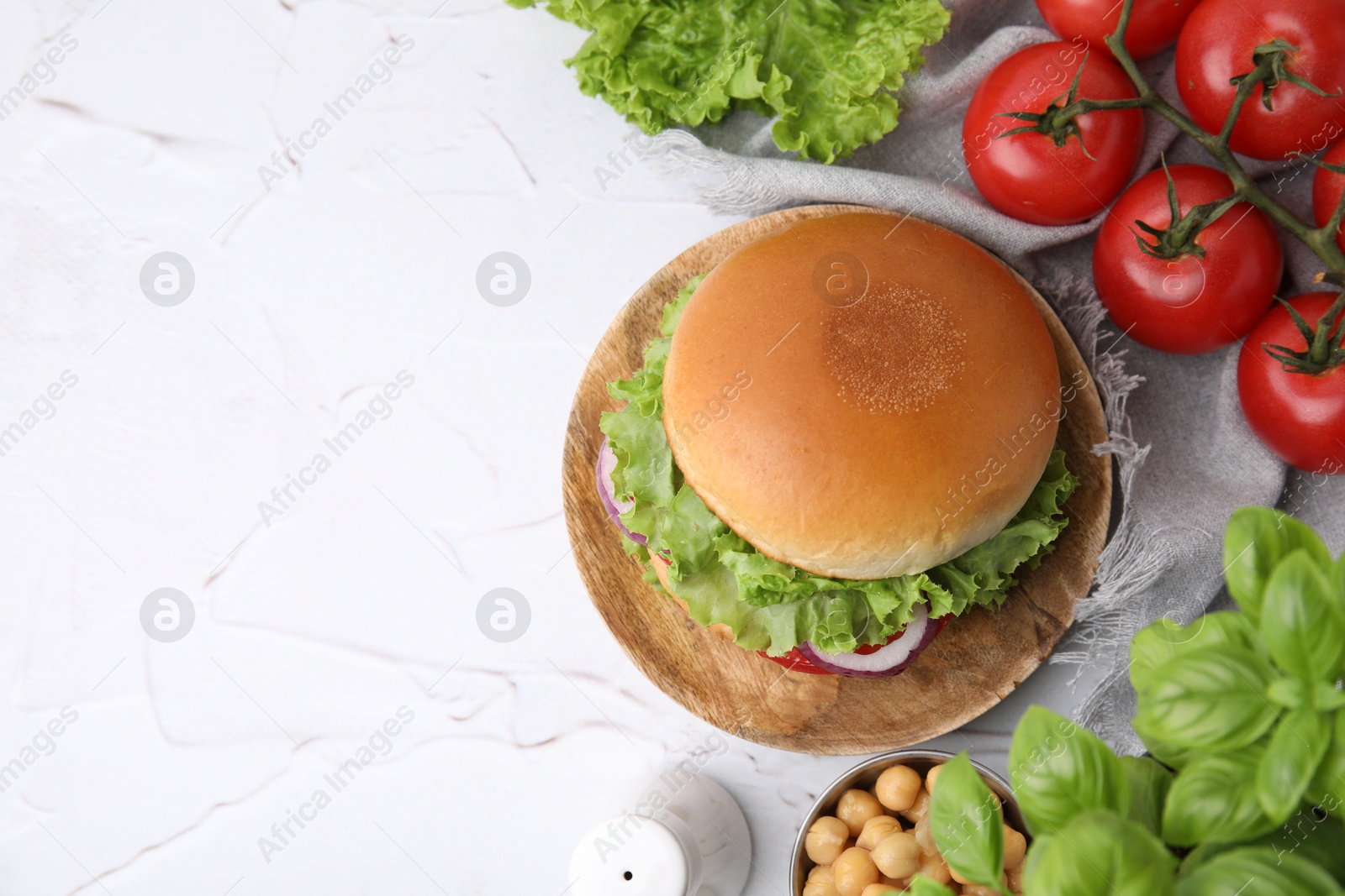 Photo of Delicious vegetarian burger with chickpea cutlet and ingredients on white textured table, flat lay. Space for text