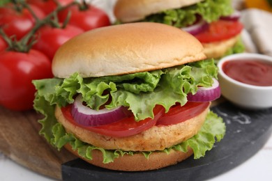 Photo of Delicious vegetarian burgers with chickpea cutlets, tomatoes and sauce on white table, closeup