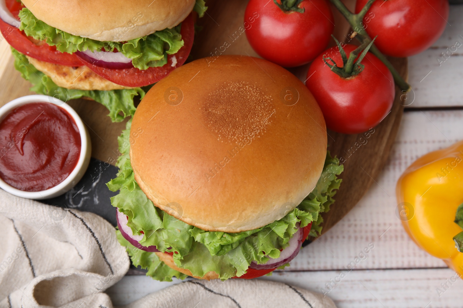 Photo of Delicious vegetarian burgers with chickpea cutlets, ingredients and sauce on white wooden table, flat lay