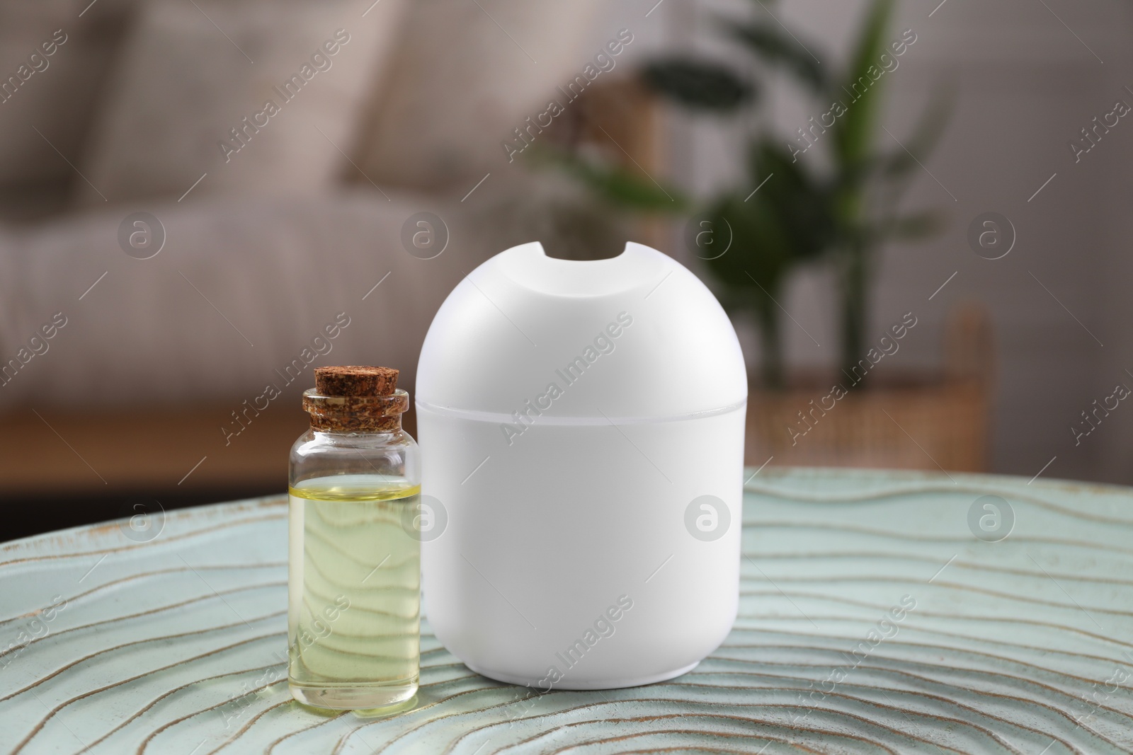 Photo of Essential oil diffuser and cosmetic product on table at home