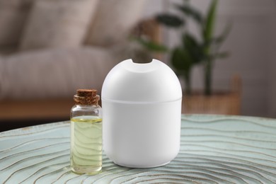 Essential oil diffuser and cosmetic product on table at home