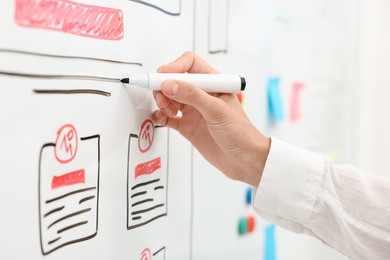 Developing UI design. Woman drawing website wireframe on whiteboard indoors, closeup