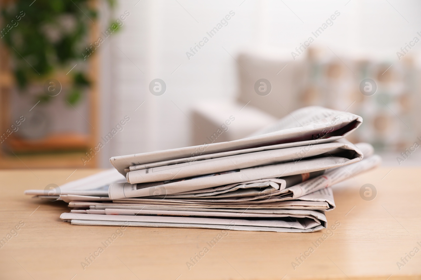 Photo of Stack of newspapers in different languages on table indoors