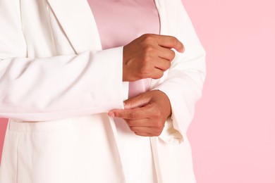 Woman in stylish jacket on pink background, closeup