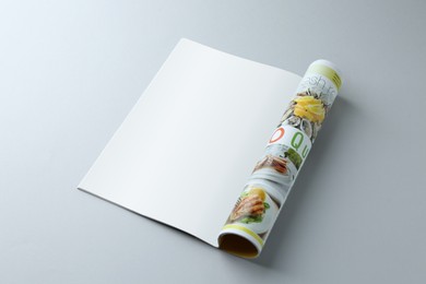 Open magazine on grey background. Mockup for design