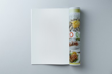 Open magazine on grey background, top view. Mockup for design