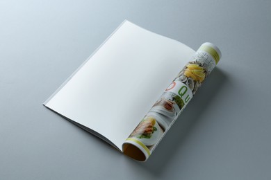 Open magazine on grey background. Mockup for design